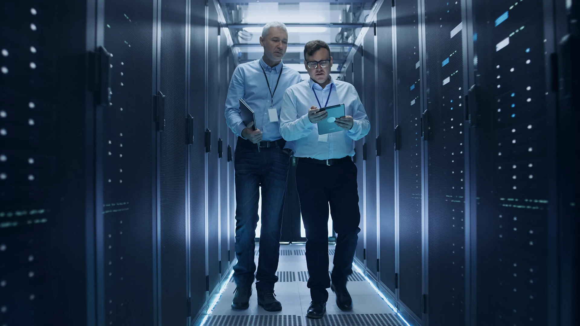 Two software architects are reviewing the storage capacitor and server room, keeping a quick check on it.